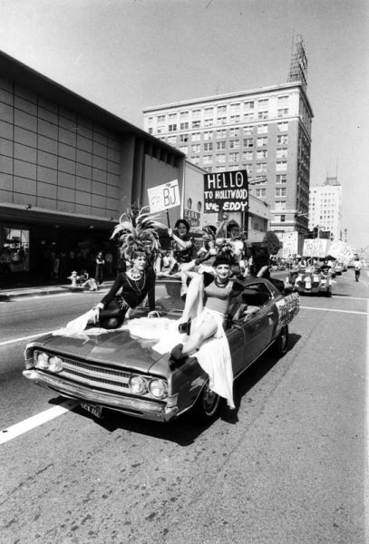 "Dressed in flowing gowns with Carmen Miranda-type headgear, a car load of participants in the Gay Pride Parade rolls down Hollywood Boulevard." Photograph dated June 23, 1977. (Photo by Lawrence Downing, Herald Examiner Collection, courtesy of the Los Angeles Public Library Collection)