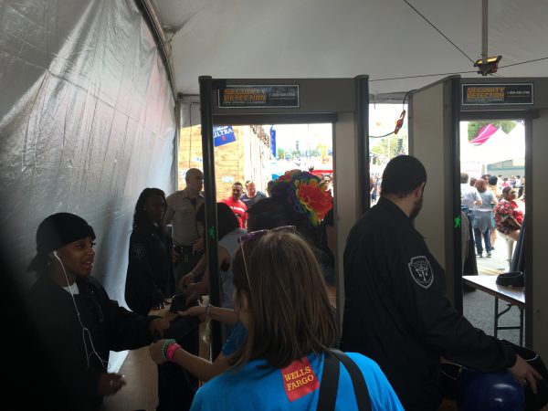 LA Pride festival attendees go through a screening device and have bags and purses checked.
